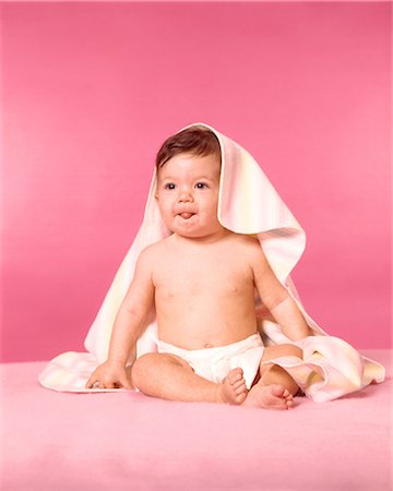 1960s BRUNETTE BABY WEARING DIAPER SITTING WITH BLANKET OVER HEAD STICKING OUT TONGUE Stock Photo - Rights-Managed, Code: 846-09012826