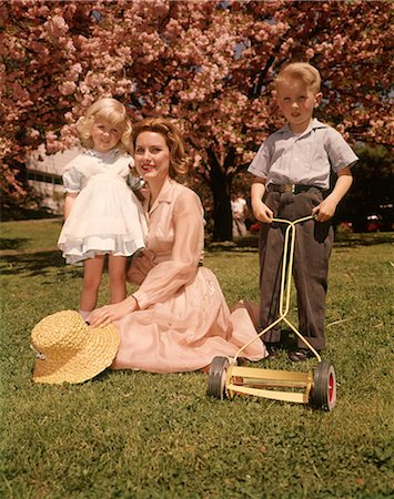 people suburban - 1950s 1960s REDHEAD MOTHER WITH CHILDREN GIRL STANDING BOY POSING WITH TOY LAWN MOWER LOOKING AT CAMERA Stock Photo - Rights-Managed, Code: 846-09012833