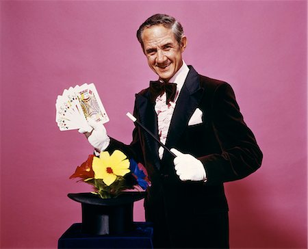 1970s MAGICIAN PERFORMING MAGIC CARD TRICK WEARING TUXEDO AND WHITE GLOVES Stock Photo - Rights-Managed, Code: 846-09012868