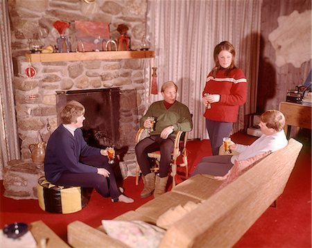 1960s GROUP OF MEN AND WOMEN RELAXING BY FIREPLACE APRES-SKI Foto de stock - Con derechos protegidos, Código: 846-09012904