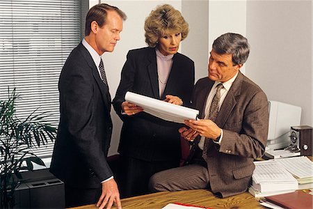 retro images of businessmen in meeting - 1980s 3 EXECUTIVES HOLDING MEETING IN OFFICE REVIEWING PAPER WORK SPREAD SHEET Stock Photo - Rights-Managed, Code: 846-09012967