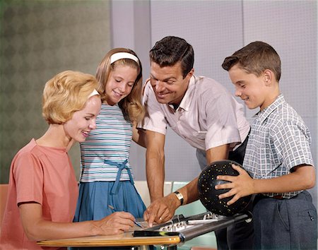 1960s HAPPY FAMILY IN BOWLING ALLEY LOOKING AT SCORE SHEETS BOY HOLDING BALL Stock Photo - Rights-Managed, Code: 846-09013003