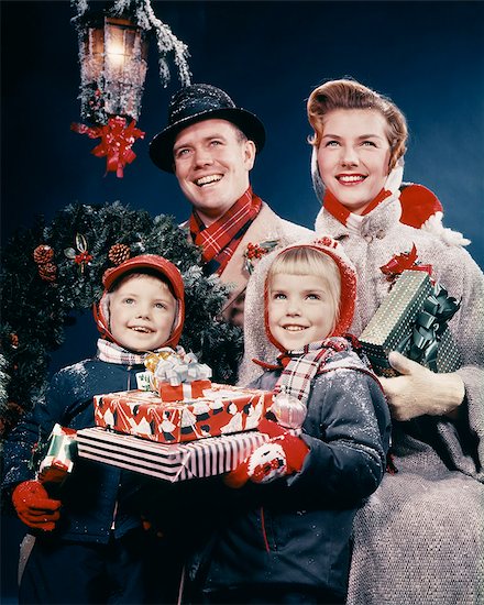 1950s FAMILY MAN WOMAN TWO KIDS HOLDING CHRISTMAS PRESENTS SMILING STANDING BENEATH LANTERN Stock Photo - Premium Rights-Managed, Artist: ClassicStock, Image code: 846-09013054