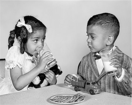 simsearch:846-09181518,k - 1960s AFRICAN AMERICAN GIRL BOY DRINKING MILK EATING COOKIES Stock Photo - Rights-Managed, Code: 846-09013076