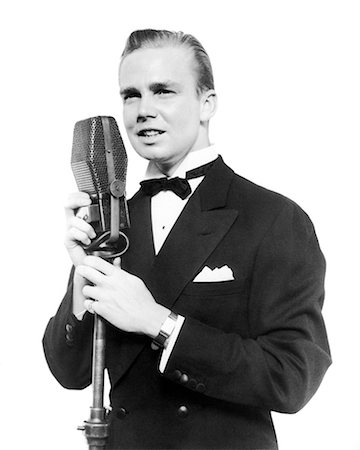 simsearch:400-08507512,k - 1920s 1930s SMILING MAN RADIO SINGER ENTERTAINER CROONER IN TUXEDO SINGING INTO MICROPHONE Fotografie stock - Rights-Managed, Codice: 846-09013094