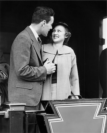1930s SMILING COUPLE MAN WOMAN HOLDING HANDS STANDING ON REAR PLATFORM OF TRAIN OBSERVATION CAR Stock Photo - Rights-Managed, Code: 846-09013102
