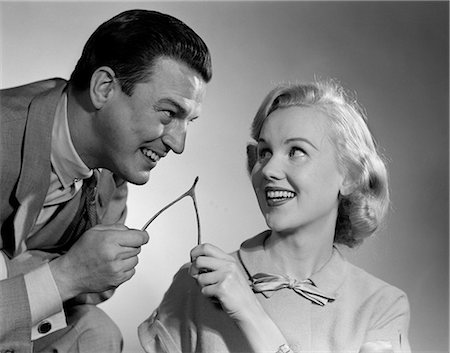 1950s COUPLE PULLING AND BREAKING A WISHBONE FOR LUCK TRADITION Stock Photo - Rights-Managed, Code: 846-09013135