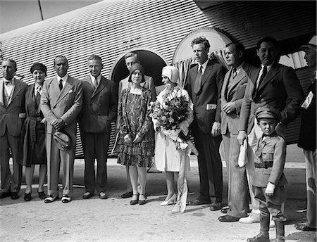 1920s AVIATOR CHARLES LINDBERGH AND HIS WIFE ANNE STANDING BY AIRPLANE WITH GROUP OF PEOPLE ON INAUGURAL FLIGHT OF TAT AIRLINE Stock Photo - Rights-Managed, Code: 846-09085252