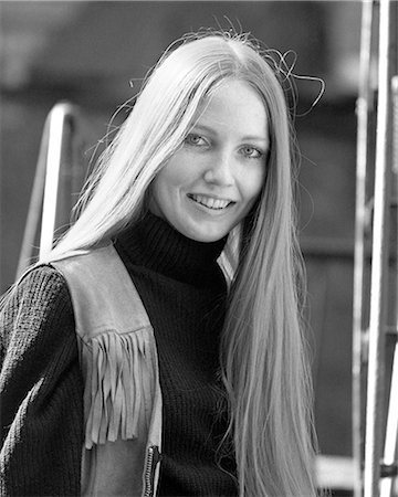 1970s SMILING YOUNG WOMAN WITH STRAIGHT BLOND HAIR PARTED IN MIDDLE WEARING FRINGED LEATHER VEST PORTRAIT LOOKING AT CAMERA Stock Photo - Rights-Managed, Code: 846-09085286