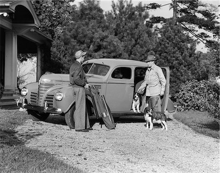 simsearch:846-08639470,k - 1930s TWO MEN STANDING BY FOUR DOOR SEDAN PACKING GUNS HUNTING GEAR AND TWO SPRINGER SPANIEL DOGS Stock Photo - Rights-Managed, Code: 846-09085283