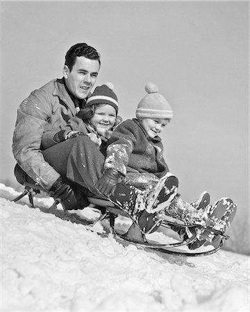 1930s 1940s FATHER TWO CHILDREN ON SLED IN SNOW GOING DOWN HILL Photographie de stock - Rights-Managed, Code: 846-09085402