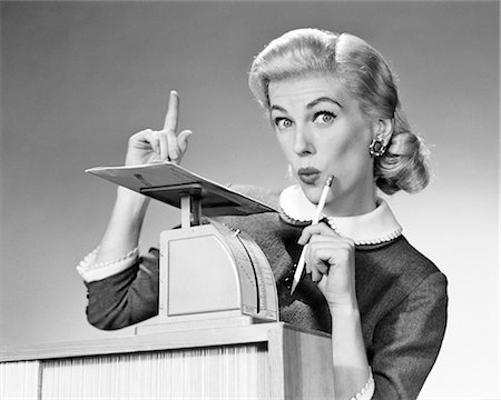 1950s BLOND WOMAN SECRETARY WEIGHING MAIL ON POSTAGE SCALE POINTING FINGER SURPRISED EXPRESSION Foto de stock - Con derechos protegidos, Código: 846-09161431