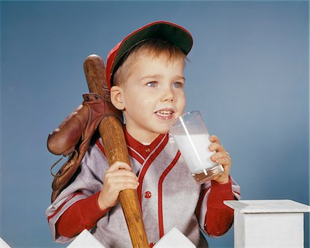 1950s 1960s BOY DRINKING MILK WEARING BASEBALL UNIFORM BY PICKET FENCE Photographie de stock - Rights-Managed, Code: 846-09161473