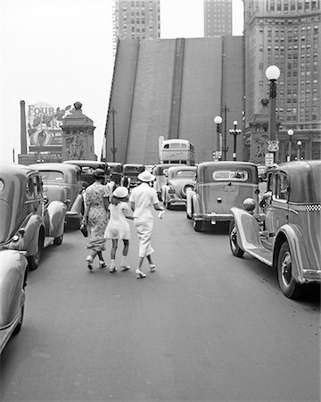 1937 TWO ANONYMOUS STYLISH WOMEN AND YOUNG GIRL CROSSING MICHIGAN AVENUE BRIDGE AMID TRAFFIC DOWNTOWN CHICAGO IL USA Stock Photo - Rights-Managed, Code: 846-09161574