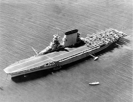 1930s 1940s 1935 AERIAL VIEW OF US NAVY SHIP WWII AIRCRAFT CARRIER USS SARATOGA WITH BIPLANE AIRCRAFT ASSEMBLED ON FLIGHT DECK Photographie de stock - Rights-Managed, Code: 846-09161586