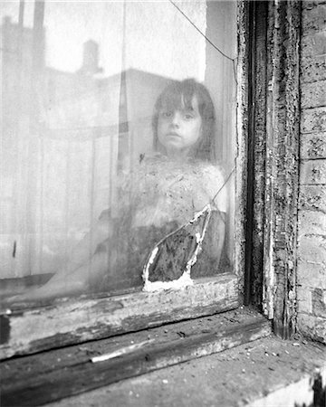 simsearch:846-09181789,k - 1970s POOR LITTLE GIRL LOOKING AT CAMERA OUT OF BROKEN WINDOW OF SLUM APARTMENT Stock Photo - Rights-Managed, Code: 846-09161598