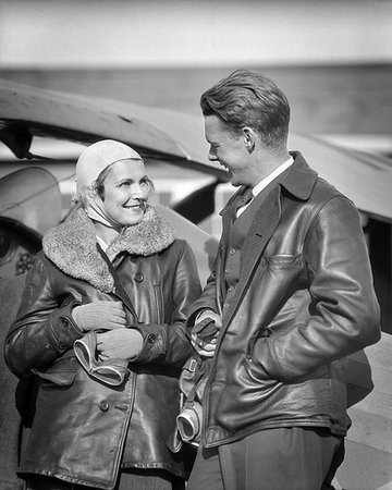 simsearch:846-03163644,k - 1930s COUPLE WEARING LEATHER JACKETS HOLDING GOGGLES LOOKING AT TALKING TO EACHOTHER STANDING BY AIRPLANE Stock Photo - Rights-Managed, Code: 846-09181504