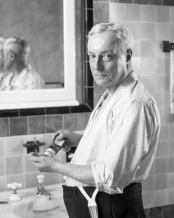 1920s SENIOR MAN STANDING IN SHIRT SLEEVES AT BATHROOM  SINK LOOKING AT CAMERA SQUEEZING GROOMING PRODUCT FROM TUBE INTO HAND Stock Photo - Rights-Managed, Code: 846-09181540