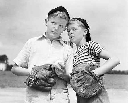 summer clothes - 1930s TWO BOYS WEARING BASEBALL CAPS AND GLOVES CATCHER AND PITCHER PLANNING STRATEGY WHISPERING Stock Photo - Rights-Managed, Code: 846-09181564