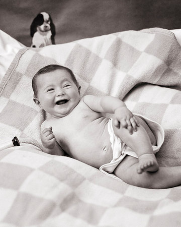 1920s HAPPY BABY POSED LYING ON SIDE WEARING CLOTH DIAPER TOY DOG ABOVE HER HEAD Foto de stock - Con derechos protegidos, Código: 846-09181588