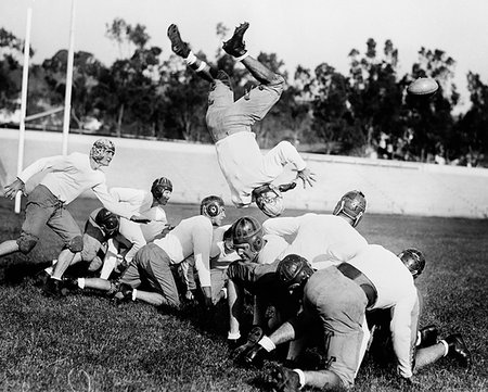 simsearch:846-05646069,k - 1930s 1940s LEATHER HELMET ERA FOOTBALL SCRIMMAGE LINE ONE PLAYER UPSIDE DOWN IN MIDAIR Stock Photo - Rights-Managed, Code: 846-09181650