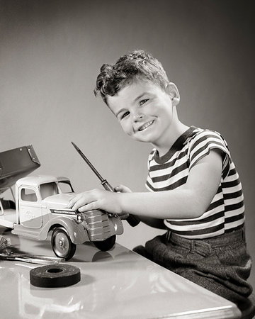 female mechanic - 1940s SMILING BOY LOOKING AT CAMERA PLAYING WITH TOY TRUCK DOING REPAIRS WITH SCREWDRIVER Foto de stock - Con derechos protegidos, Código: 846-09181665