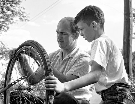 simsearch:846-08639474,k - 1950s 1960s FATHER AND SON FIXING TIRE ON BICYCLE Stockbilder - Lizenzpflichtiges, Bildnummer: 846-09181691