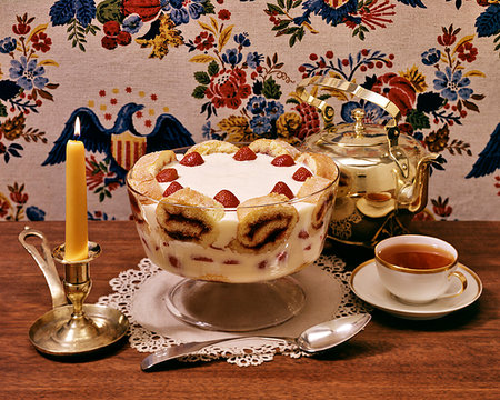 simsearch:846-05646907,k - 1770s COLONIAL AMERICAN TRIFLE DESSERT IN GLASS COMPOTE DISH LAYERS OF SPONGE CAKE FRUIT CUSTARD WHIPPED CREAM AND CUP OF TEA Stockbilder - Lizenzpflichtiges, Bildnummer: 846-09181771