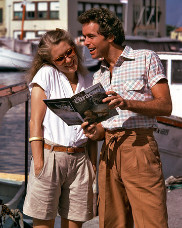 1970s 1980s HAPPY COUPLE MAN WOMAN SMILING READING TRAVEL BROCHURE MARINA VACATION Stock Photo - Rights-Managed, Code: 846-09181869