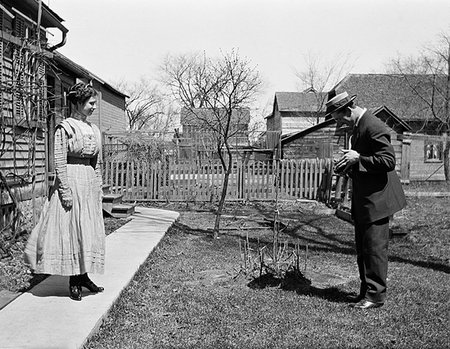 1900s 1910s TURN OF THE 20TH CENTURY MAN TAKING PICTURE OF WOMAN STANDING IN FRONT OF HOUSE Photographie de stock - Rights-Managed, Code: 846-09181929