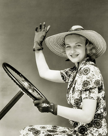 retro woman car steering wheel - 1930s 1940s SMILING WOMAN WEARING STRAW HAT SUN DRESS DRIVING GLOVES WAVING HOLDING AUTOMOBILE STEERING WHEEL LOOKING AT CAMERA Stock Photo - Rights-Managed, Code: 846-09181920