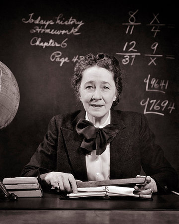 effrayé - 1940s SMILING MIDDLE AGED SCHOOL TEACHER AT DESK BESIDE GLOBE HOLDING RULER LOOKING AT CAMERA MATH ON BLACKBOARD Photographie de stock - Rights-Managed, Code: 846-09181992
