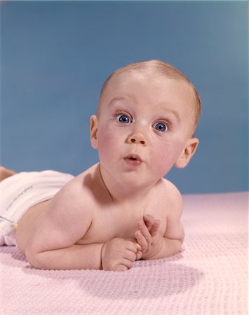 1960s BABY LAYING ON STOMACH LOOKING SURPRISED Foto de stock - Con derechos protegidos, Código: 846-02794024