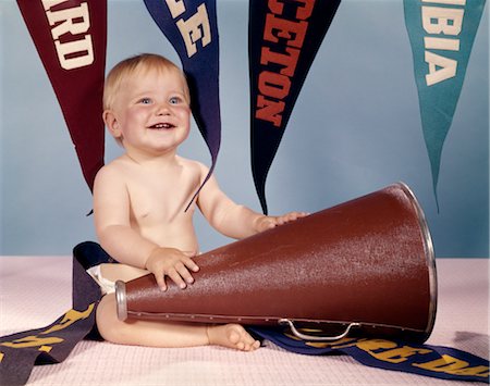 1960s SMILING HAPPY BABY GIRL WITH MEGAPHONE SURROUNDED BY PENNANTS Stock Photo - Rights-Managed, Code: 846-02794036