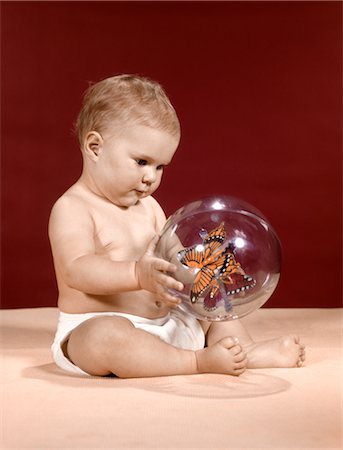 ANNÉES 1960 BÉBÉ ASSIS MAINTENANT CLAIR JOUET BALLE À PAPILLONS À L'INTÉRIEUR Photographie de stock - Rights-Managed, Code: 846-02794048