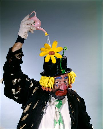 HOBO STYLE CLOWN ARROSAGE DAISY QUI SORTENT DE CHAPEAU HAUT DE FORME AVEC MINUSCULE PEUT DRÔLE JARDINAGE CROISSANCE NOURRIR PERFORMER TRAVAIL Photographie de stock - Rights-Managed, Code: 846-02794103