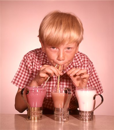 strawberry vanilla chocolate ice cream - 1950s 1960s BLOND BOY DRINKING THREE MILKSHAKES STRAWBERRY CHOCOLATE VANILLA THROUGH STRAWS AT SAME TIME Foto de stock - Con derechos protegidos, Código: 846-02794215