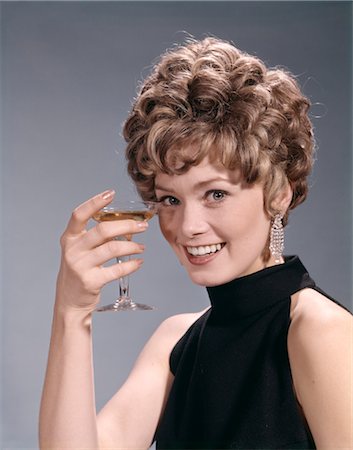 people with alcoholic drinks retro - 1960s 1970s PORTRAIT GLAMOUR WOMAN IN BLACK DRESS EARRINGS HOLDING A COCKTAIL Stock Photo - Rights-Managed, Code: 846-02794236