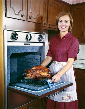 dinner home not children - 1960s SMILING WOMAN TAKING TURKEY OUT OF OVEN INDOOR FOOD POULTRY Stock Photo - Rights-Managed, Code: 846-02794364