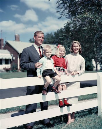 simsearch:846-05646225,k - 1950s 1960s FAMILY PORTRAIT MOTHER FATHER DAUGHTER SON AT WHITE FENCE OF SUBURBAN HOME Foto de stock - Direito Controlado, Número: 846-02794425