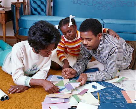 1960s AFRICAN AMERICAN FAMILY OF 3 MOM DAD DAUGHTER TOGETHER LOOK AT PAINT CHIPS BLUEPRINTS COLOR SAMPLES NEW HOME Foto de stock - Con derechos protegidos, Código: 846-02794480