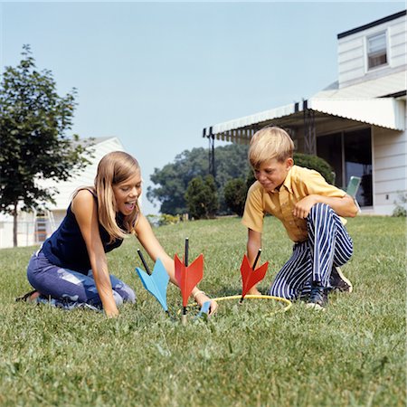 fléchettes (jeu) - ANNÉES 1970 GARÇON FILLE JOUANT PELOUSE FLÉCHETTES JEU IN BACKYARD Photographie de stock - Rights-Managed, Code: 846-02794504