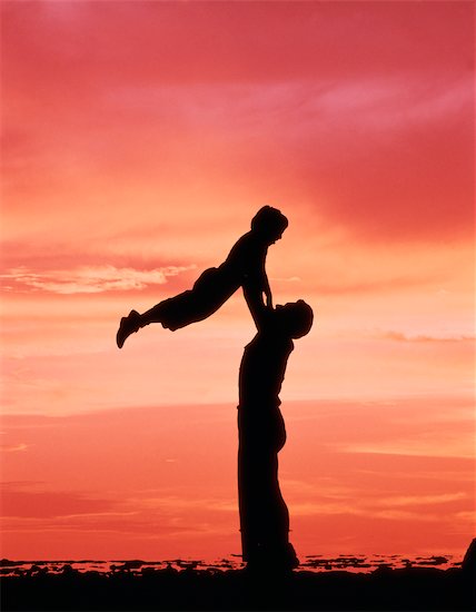 1970s SILHOUETTE MAN FATHER LIFTING BOY CHILD SON UP IN AIR AGAINST RED ORANGE SUNSET Stock Photo - Premium Rights-Managed, Artist: ClassicStock, Image code: 846-02794518