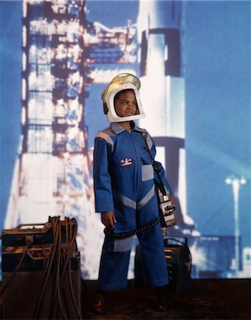 rocket ship child - 1970s AFRICAN AMERICAN BOY SPACE SUIT COSTUME HELMET ROCKET BACKGROUND ASTRONAUT CAREER Stock Photo - Rights-Managed, Code: 846-02794529
