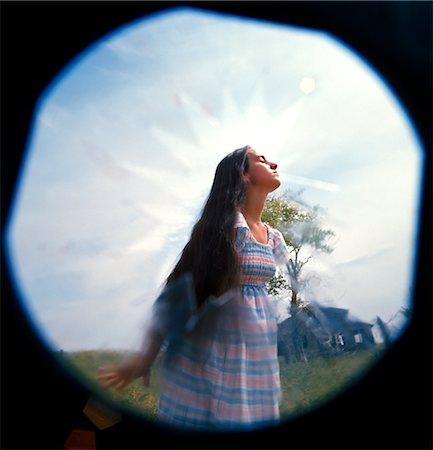 1970s GIRL WOMAN MOOD MOODY MEADOW SOFT FOCUS FISHEYE LENS ANGRY ALIENATED SERIOUS TROUBLED LOST ABANDONED HOUSE Fotografie stock - Rights-Managed, Codice: 846-02794547