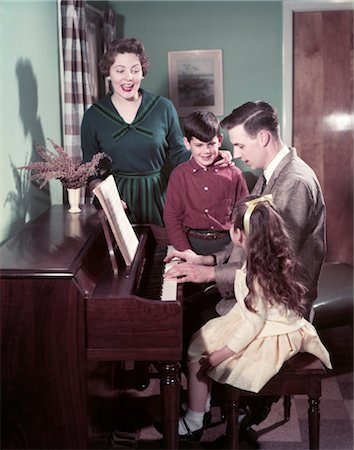 simsearch:846-02793174,k - 1950s FAMILY MAN FATHER PLAYING PIANO WOMAN MOTHER BOY SON GIRL DAUGHTER SINGING IN LIVING ROOM Foto de stock - Con derechos protegidos, Código: 846-02794737