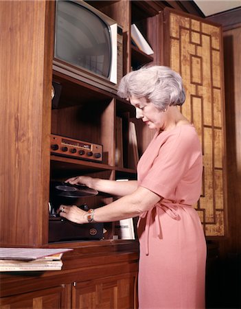 RETRO WOMAN 1970s PLAYING RECORDS PUTTING RECORD ON PLAYER Foto de stock - Direito Controlado, Número: 846-02794730