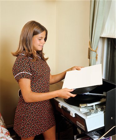 1960s TEEN GIRL PUTTING RECORD TO PLAY ON PHONOGRAPH Foto de stock - Direito Controlado, Número: 846-02794742