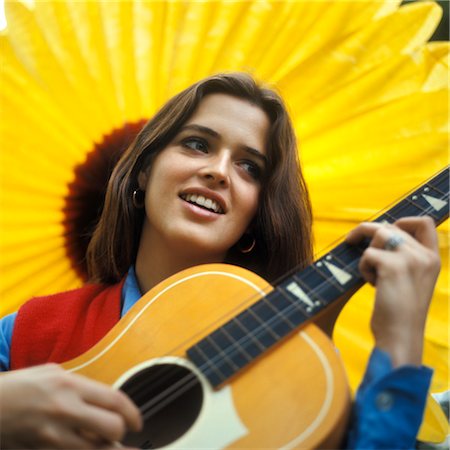 simsearch:846-03165060,k - 1970s SMILING TEENAGED GIRL PLAYING ACOUSTIC GUITAR WITH LARGE YELLOW SUNFLOWER BACKDROP Stock Photo - Rights-Managed, Code: 846-02794743