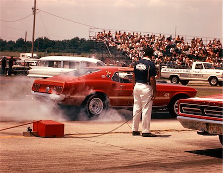 simsearch:846-02794609,k - 1970 1970s PIT MECHANIC BY RACE CAR BURNING RUBBER DRAG RACING BROWNSVILLE INDIANA SPEED MECHANIC CARS Stock Photo - Rights-Managed, Code: 846-02794756
